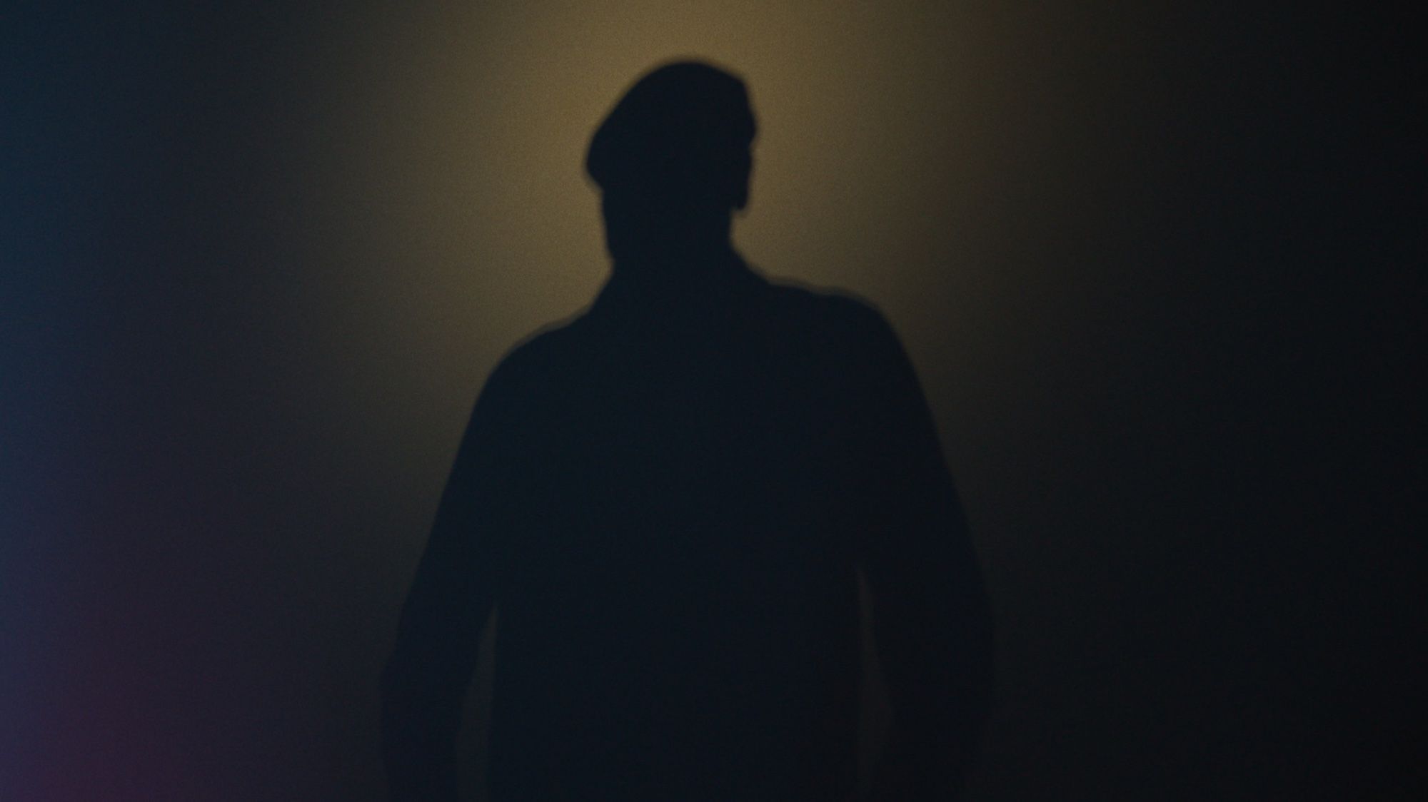 A silhouetted figure against a warm haze.