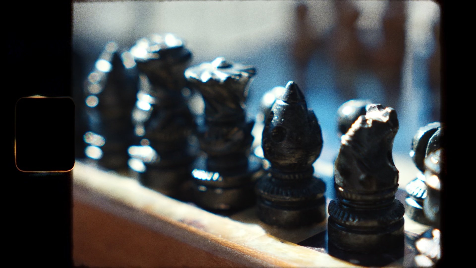 Carved black chess pieces in shallow focus.