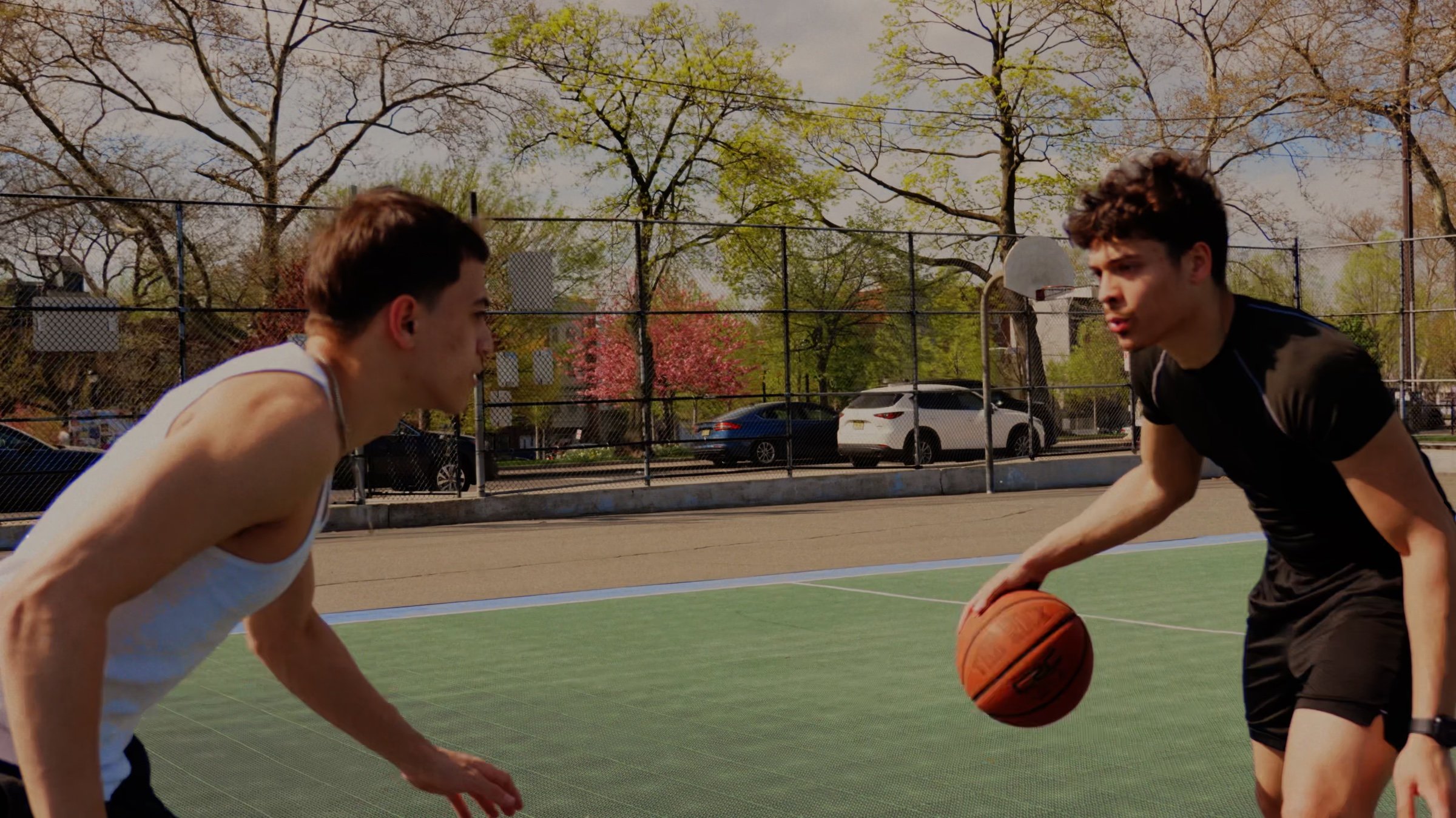 Two players face off on a green and blue outdoor court.