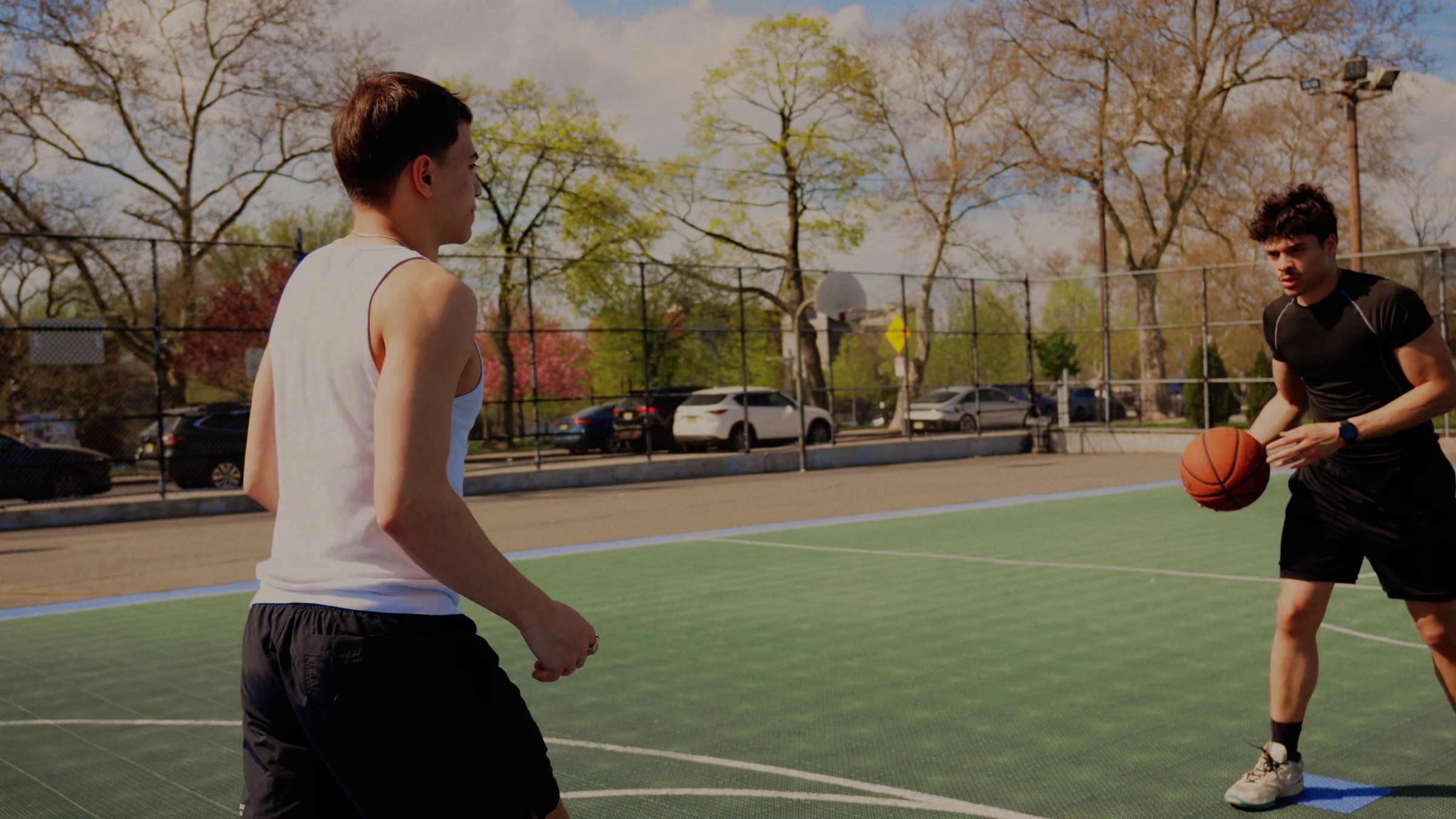 A player dribbles toward a defender on the court.