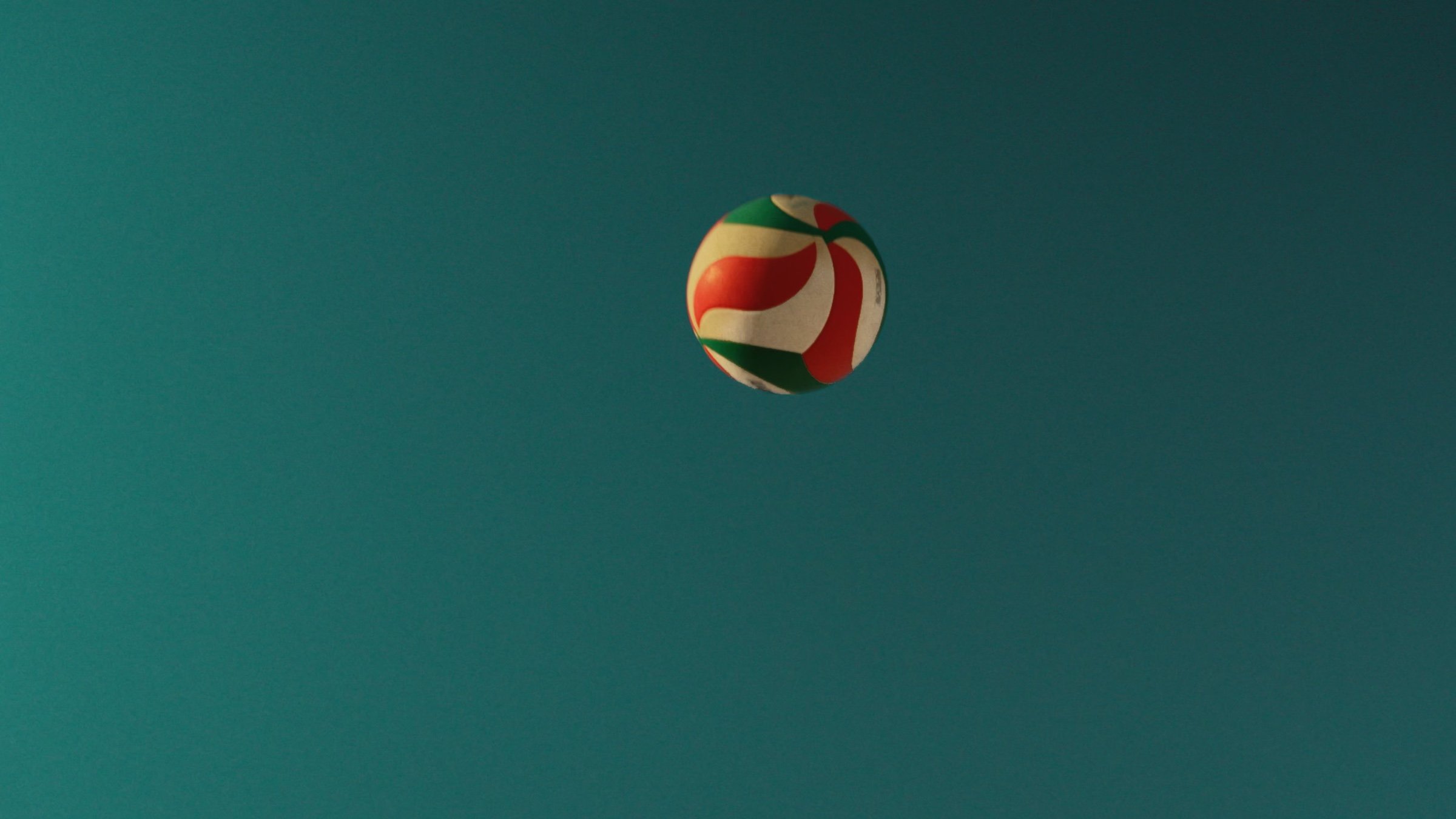 A volleyball against a deep teal sky.