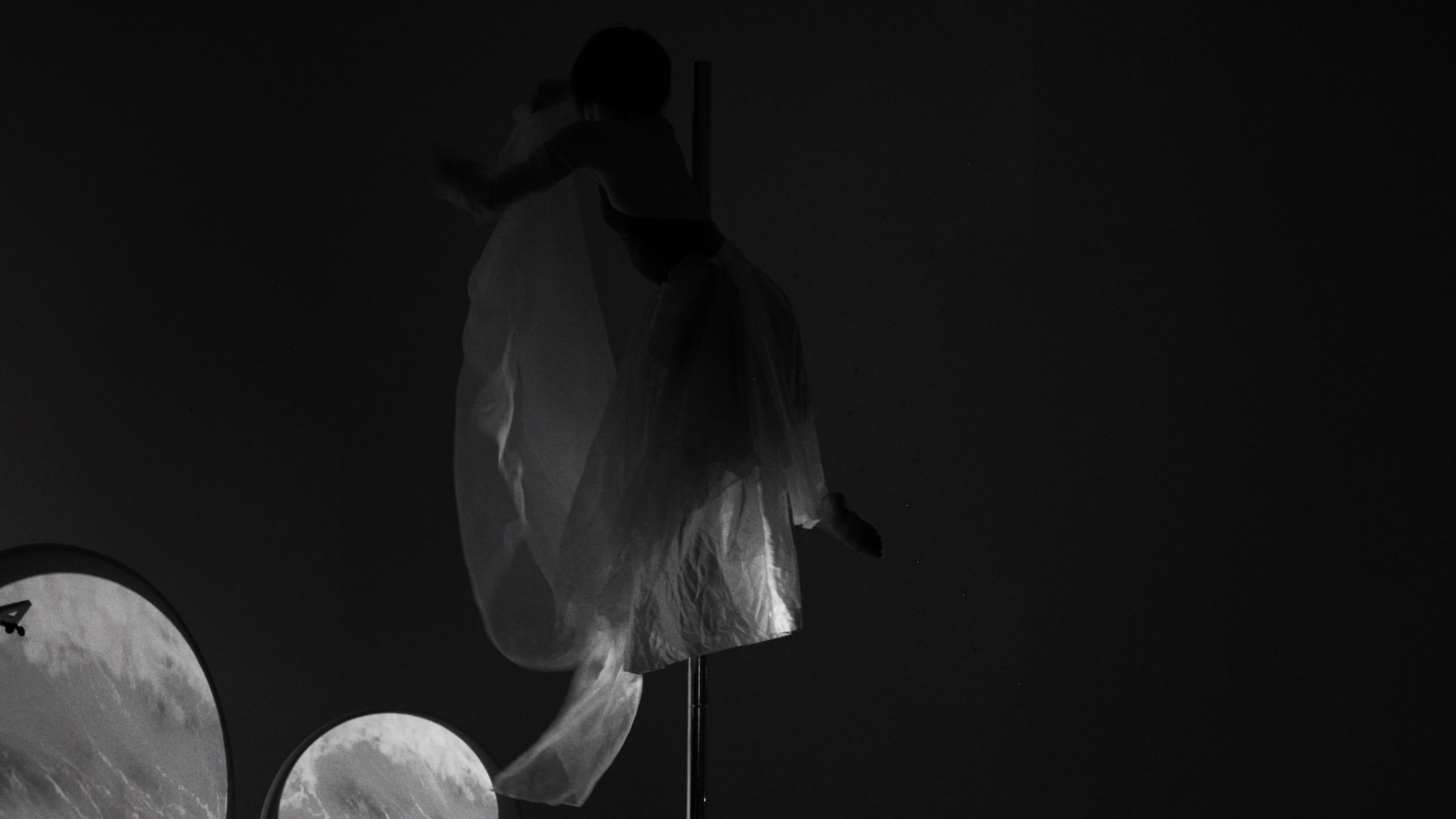 Black and white: a dancer's white fabric caught mid-turn.